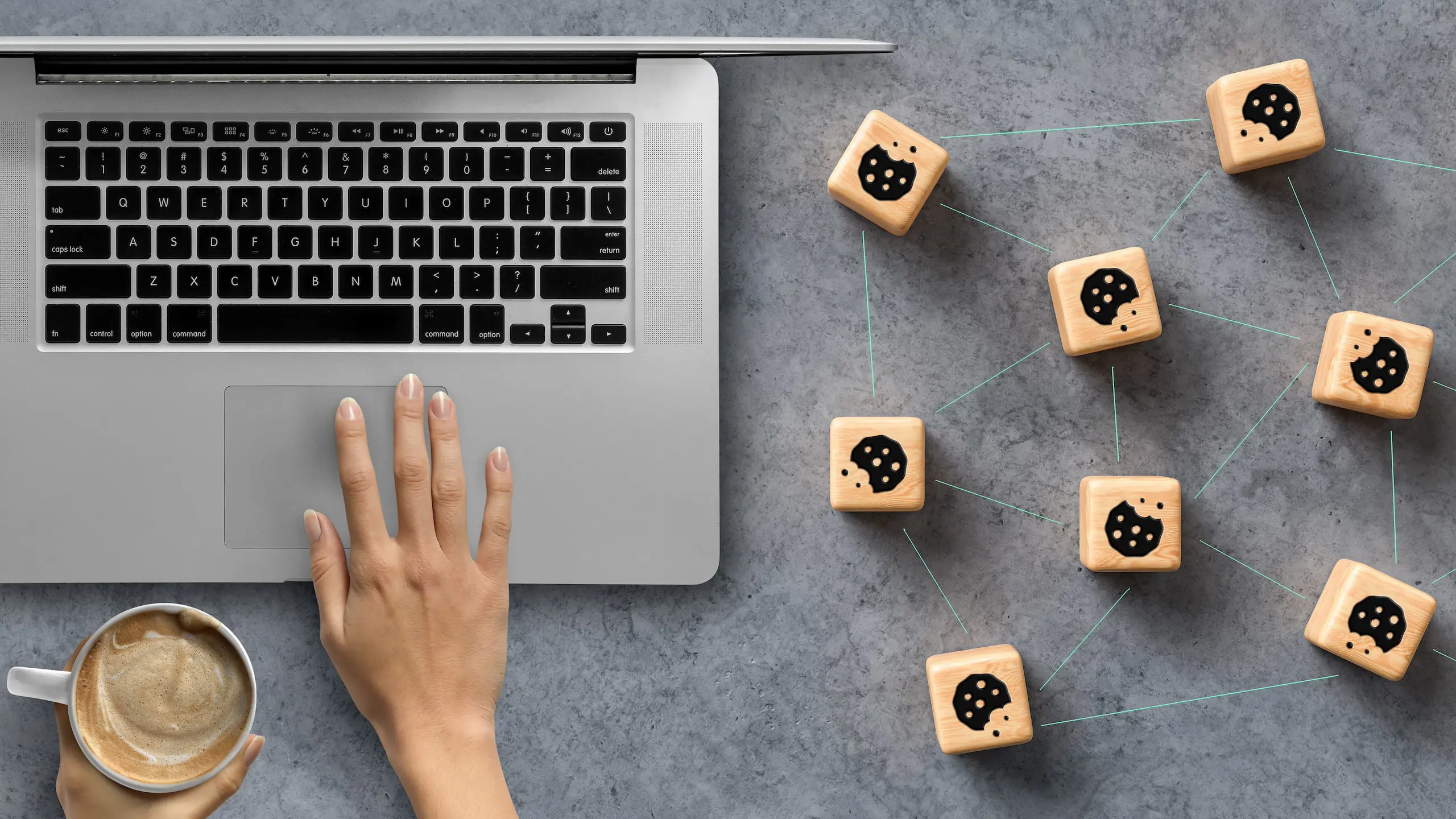 Hand typing on laptop with cookies shaped cubes